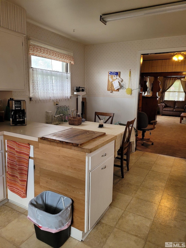 449 W 2nd St, Winnemucca, NV 89445 - kitchen with wallpapered walls, plenty of natural light, and white cabinetry