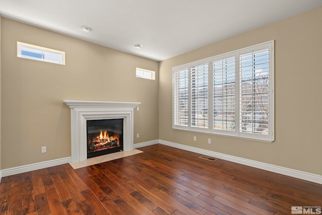 6540 Monticello Ct, Reno, NV 89519 - unfurnished living room featuring hardwood / wood-style floors, a fireplace with flush hearth, baseboards, and plenty of natural light