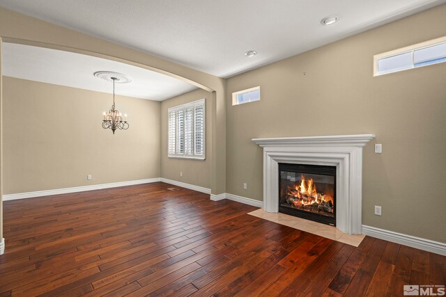 6540 Monticello Ct, Reno, NV 89519 - unfurnished living room with a chandelier, hardwood / wood-style floors, healthy amount of natural light, and a fireplace with flush hearth