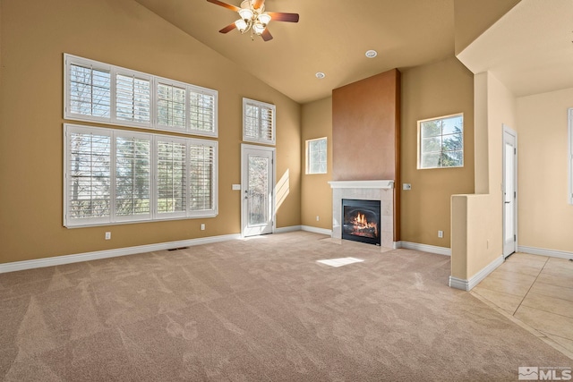 6540 Monticello Ct, Reno, NV 89519 - unfurnished living room with high vaulted ceiling, carpet, a ceiling fan, a tiled fireplace, and baseboards