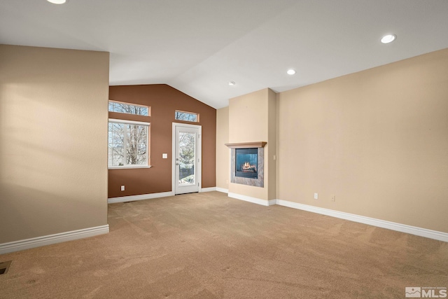 6540 Monticello Ct, Reno, NV 89519 - unfurnished living room featuring carpet floors, a glass covered fireplace, vaulted ceiling, baseboards, and recessed lighting