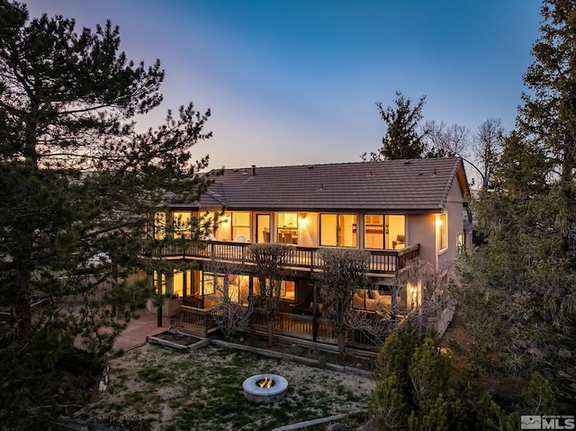 80 Cassas Ct, Reno, NV 89511 - back of property at dusk featuring a tile roof, stucco siding, and a deck