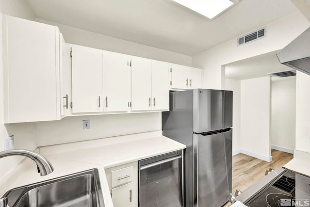 2555 Clear Acre Ln Unit 89/2, Reno, NV 89512 - kitchen featuring appliances with stainless steel finishes, a sink, light countertops, light wood-style floors, and white cabinetry