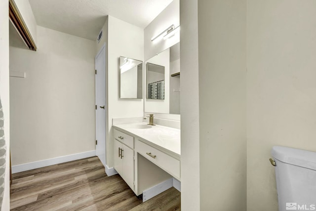 2555 Clear Acre Ln Unit 89/2, Reno, NV 89512 - bathroom with wood finished floors, toilet, vanity, and baseboards
