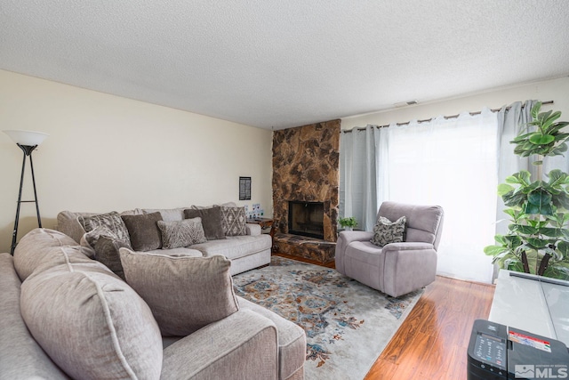 13846 Lear Blvd, Reno, NV 89506 - living room featuring wood finished floors, a textured ceiling, and a stone fireplace