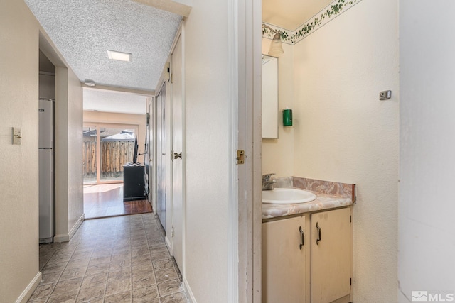 13846 Lear Blvd, Reno, NV 89506 - bathroom featuring baseboards, vanity, a textured ceiling, and stone finish floors