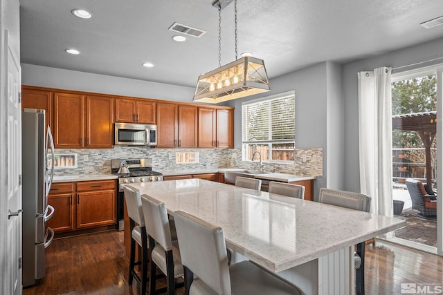 385 Mustengo Ct, Reno, NV 89506 - kitchen with appliances with stainless steel finishes, healthy amount of natural light, tasteful backsplash, brown cabinets, and recessed lighting