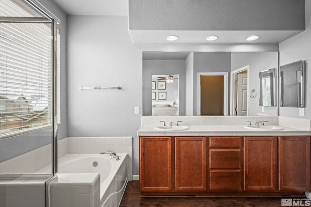 385 Mustengo Ct, Reno, NV 89506 - bathroom with healthy amount of natural light, a bath, double vanity, and wood finished floors