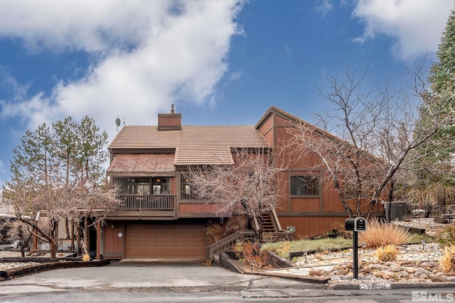 12880 Roseview Ln, Reno, NV 89511 - view of front facade featuring a chimney, asphalt driveway, a garage, and central air condition unit