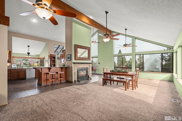 12880 Roseview Ln, Reno, NV 89511 - dining space with ceiling fan, high vaulted ceiling, dark colored carpet, a textured ceiling, and a fireplace with flush hearth