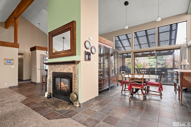 12880 Roseview Ln, Reno, NV 89511 - dining area with a high ceiling, a fireplace, baseboards, stone tile floors, and beam ceiling