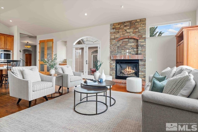 1005 Desert Jewel Ct, Reno, NV 89511 - living area with wood finished floors, a stone fireplace, recessed lighting, lofted ceiling, and arched walkways