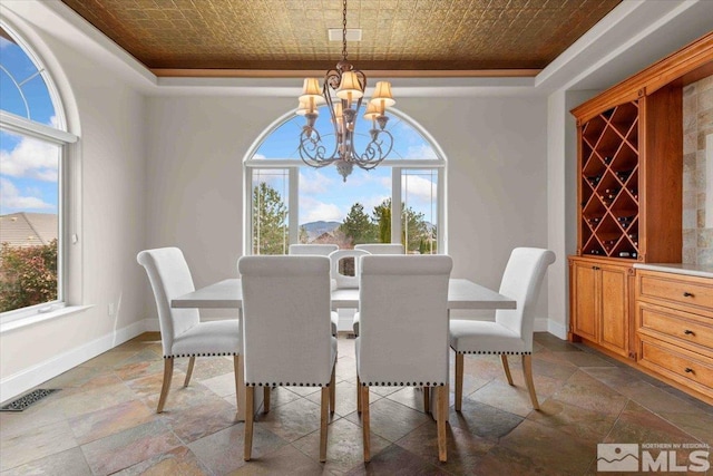 1005 Desert Jewel Ct, Reno, NV 89511 - dining area featuring a chandelier, stone tile flooring, an ornate ceiling, a raised ceiling, and baseboards