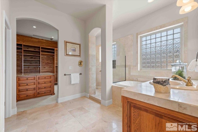 1005 Desert Jewel Ct, Reno, NV 89511 - full bathroom featuring a walk in shower, built in shelves, a bath, vanity, and healthy amount of natural light