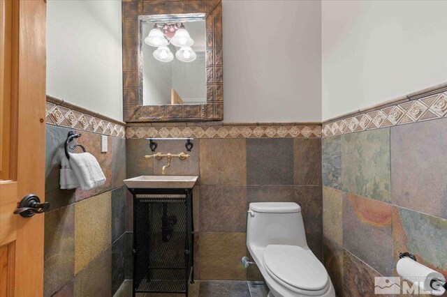 1005 Desert Jewel Ct, Reno, NV 89511 - half bathroom featuring tile walls, toilet, and a wainscoted wall