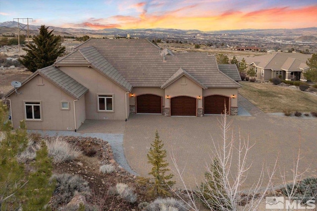 1005 Desert Jewel Ct, Reno, NV 89511 - view of front of property featuring stucco siding, a garage, driveway, stone siding, and a tiled roof