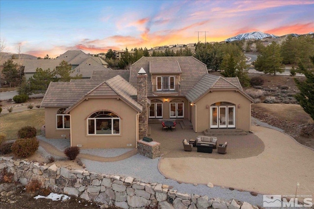 1005 Desert Jewel Ct, Reno, NV 89511 - rear view of property with outdoor lounge area, stucco siding, a patio, a mountain view, and french doors