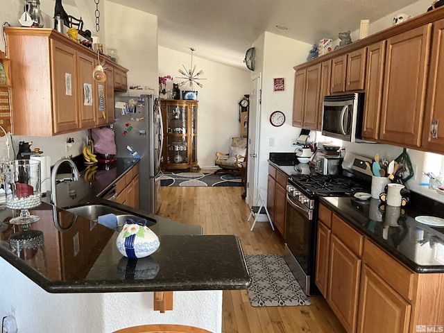 5710 Sarah Rd, Fallon, NV 89406 - kitchen featuring appliances with stainless steel finishes, light wood-style floors, a sink, lofted ceiling, and brown cabinets