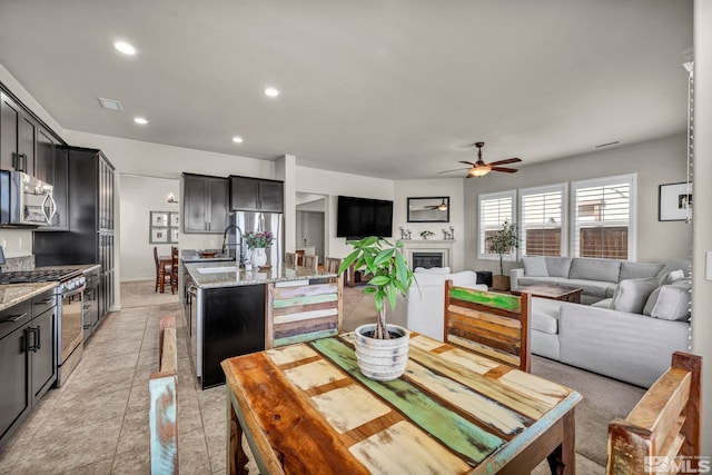 dining area with a ceiling fan, recessed lighting, and a glass covered fireplace