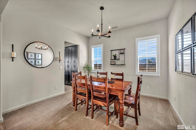 dining space with a chandelier, light carpet, and plenty of natural light