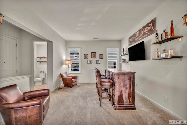 indoor dry bar with carpet flooring and baseboards