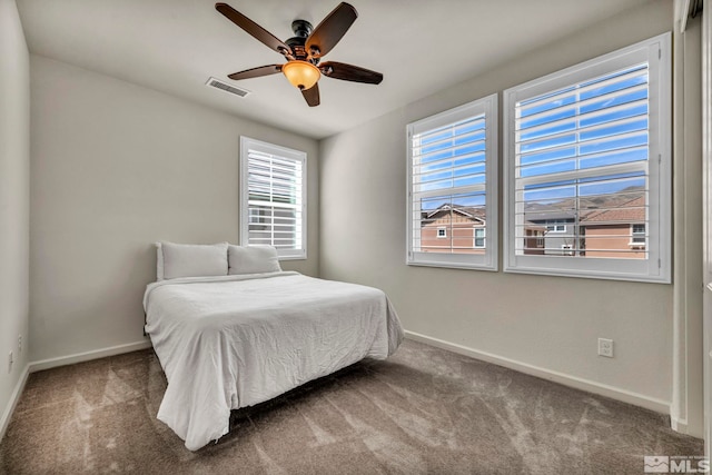 carpeted bedroom featuring baseboards and ceiling fan