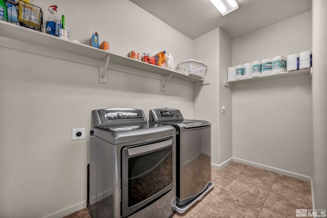 clothes washing area featuring washer and dryer and baseboards