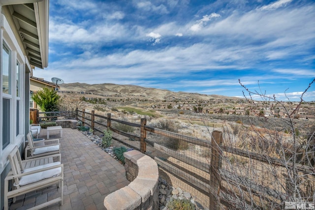 fenced backyard featuring a mountain view and a patio area