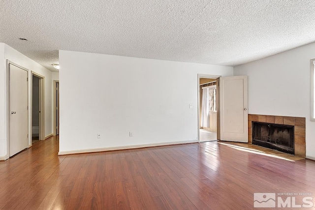 2375 Tripp Dr, Reno, NV 89512 - unfurnished living room featuring a textured ceiling, wood finished floors, a fireplace, and baseboards