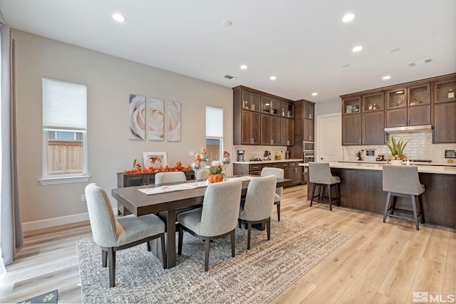 dining room with recessed lighting, plenty of natural light, light wood-style flooring, and baseboards