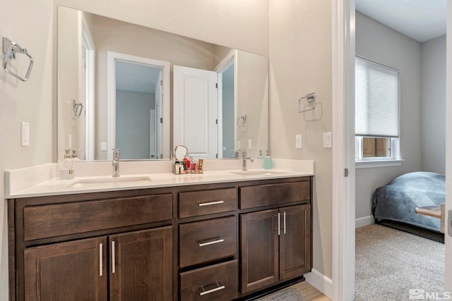 bathroom with double vanity and baseboards