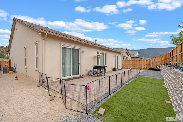back of house featuring central AC, stucco siding, and a patio