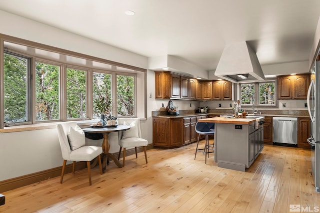 4840 Keshmiri Pl, Reno, NV 89519 - kitchen featuring appliances with stainless steel finishes, a breakfast bar area, a center island, premium range hood, and butcher block counters