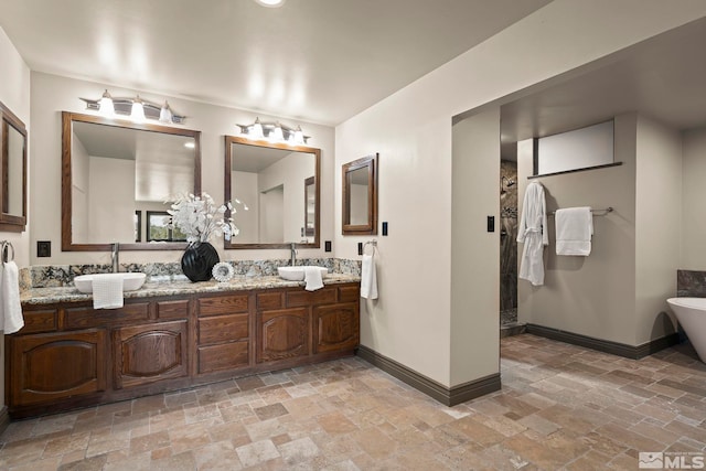 4840 Keshmiri Pl, Reno, NV 89519 - bathroom featuring stone tile floors, baseboards, a soaking tub, and a walk in shower
