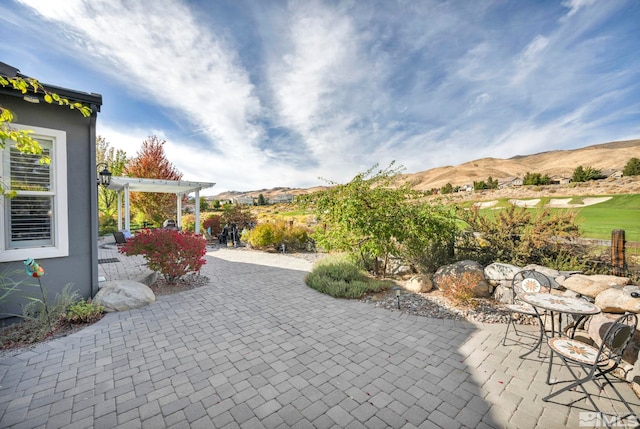 view of patio / terrace with a pergola and a mountain view
