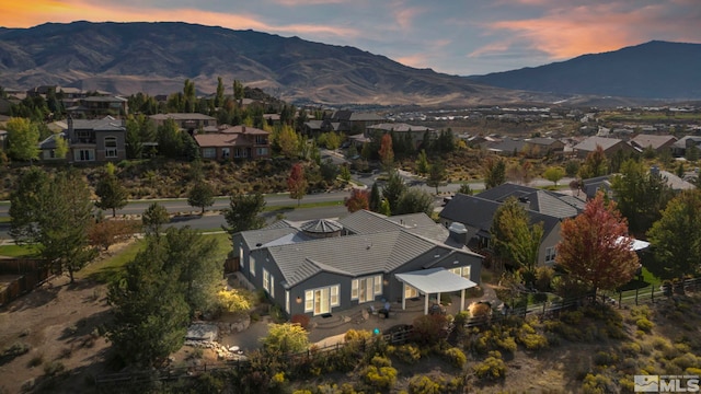 aerial overview of property's location with a mountain backdrop and nearby suburban area
