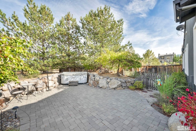 view of patio / terrace featuring a hot tub and a fenced backyard