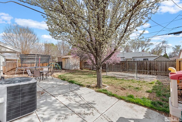 11 E P St, Sparks, NV 89431 - view of patio / terrace with a trampoline, a storage unit, a fenced backyard, an outbuilding, and cooling unit