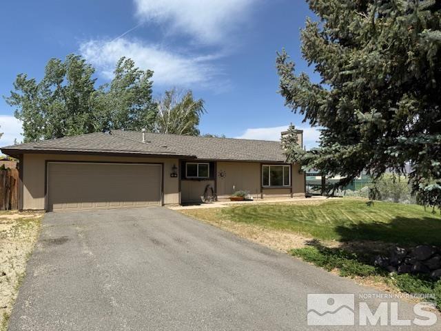 single story home featuring an attached garage, asphalt driveway, stucco siding, and a chimney