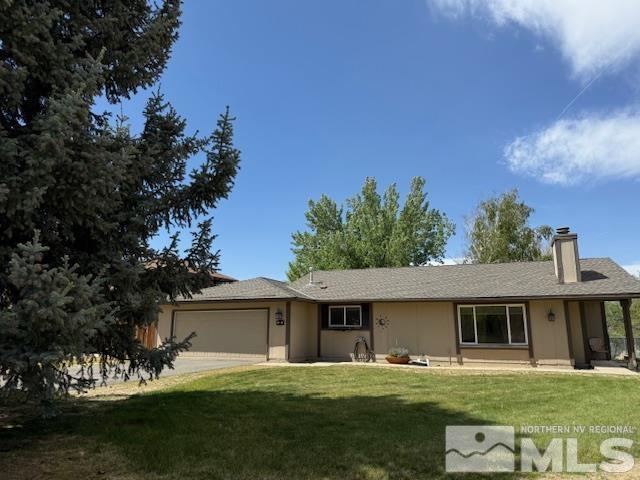 ranch-style home with a garage, a front lawn, a chimney, and driveway