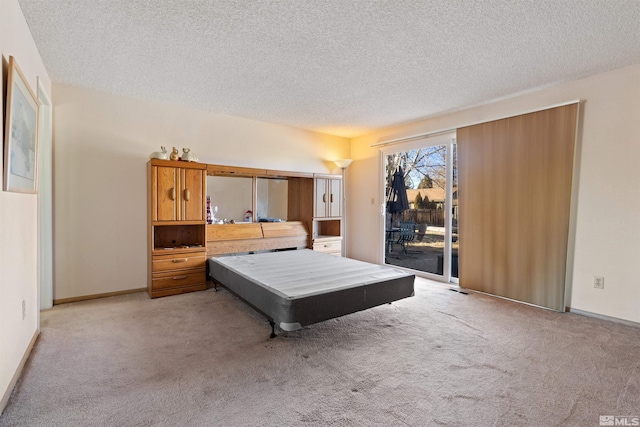 bedroom featuring access to outside, a textured ceiling, light carpet, and baseboards