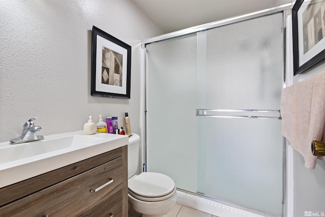 full bath featuring a stall shower, toilet, vanity, and tile patterned flooring