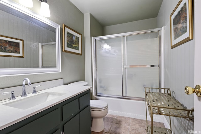 bathroom featuring vanity, toilet, shower / bath combination with glass door, and tile patterned flooring