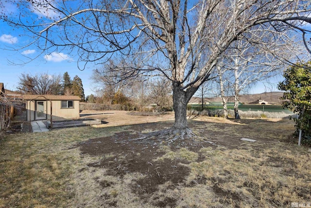 view of yard featuring an outdoor structure and fence