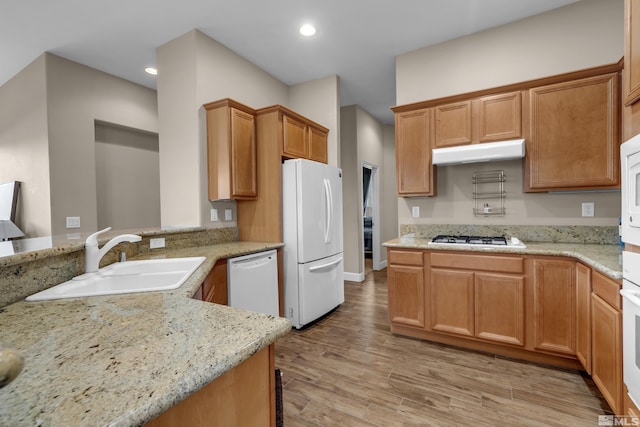 5807 Desert Mirage Dr, Sparks, NV 89436 - kitchen with white appliances, a sink, under cabinet range hood, light wood-style flooring, and recessed lighting