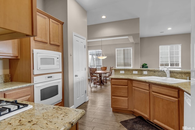 5807 Desert Mirage Dr, Sparks, NV 89436 - kitchen with white appliances, a sink, light wood-style flooring, light stone countertops, and recessed lighting