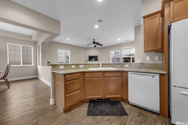 5807 Desert Mirage Dr, Sparks, NV 89436 - kitchen featuring white appliances, a sink, a peninsula, ceiling fan, and light wood-type flooring