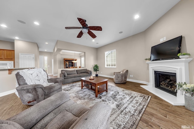 5807 Desert Mirage Dr, Sparks, NV 89436 - living area featuring a glass covered fireplace, a ceiling fan, light wood-style floors, baseboards, and recessed lighting
