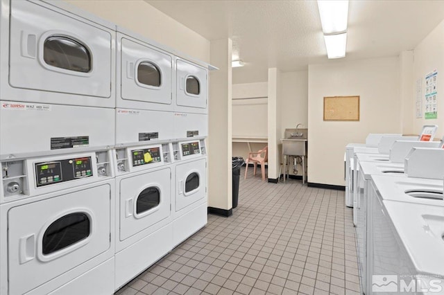2955 Lakeside Dr Unit 223, Reno, NV 89509 - communal laundry room featuring stacked washer and clothes dryer, washing machine and dryer, light tile patterned flooring, and baseboards