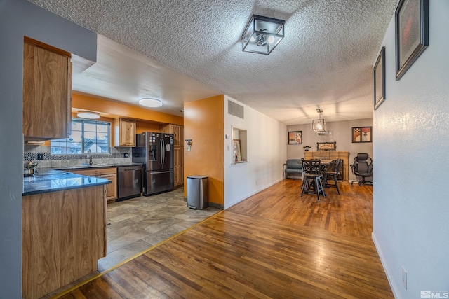 250 Galleron Way, Sparks, NV 89431 - kitchen featuring stainless steel appliances, light wood finished floors, a textured ceiling, baseboards, and dark countertops